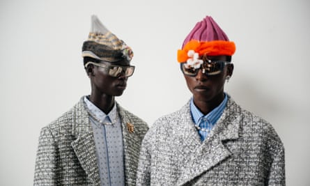Two models posing with tweed-style jackets, pointed fabric hats and sunglasses