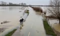 People walking near Whittlesey, Cambridgeshire, after the River Nene burst its banks, 2020.
