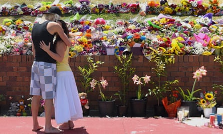 Members of the public react as they leave floral tributes outside the main entrance to Dreamworld, where four people died on Tuesday on the Thunder River Rapids ride.