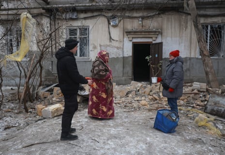 Residents stand near their apartment building that was struck by a drone.