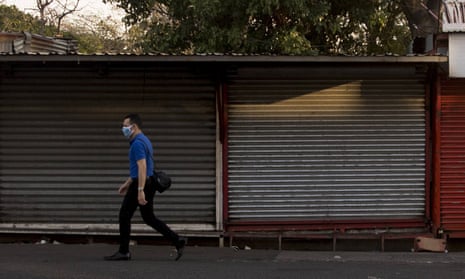 A person walks past closed stores in Managua, Nicaragua, 8 April 2020.