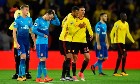 Mesut Ozil looks down at the final whistle as Troy Deeney and José Holebas celebrate.