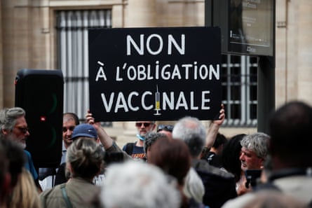 A sign against vaccinations being held aloft in a protest