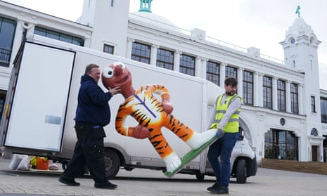 Workers carry a large sculpture of Aardman’s Tiger Morph character from a van