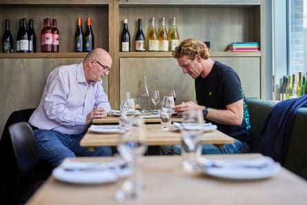 Matt and Sam reading menus at a restaurant table