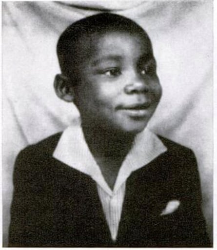 a black and white photo of a young boy smiling