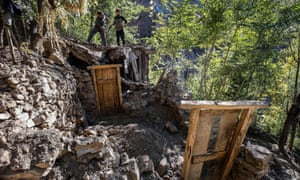 Pakistanis remove debris from a home destroyed in the October earthquake in the Chitral valley.