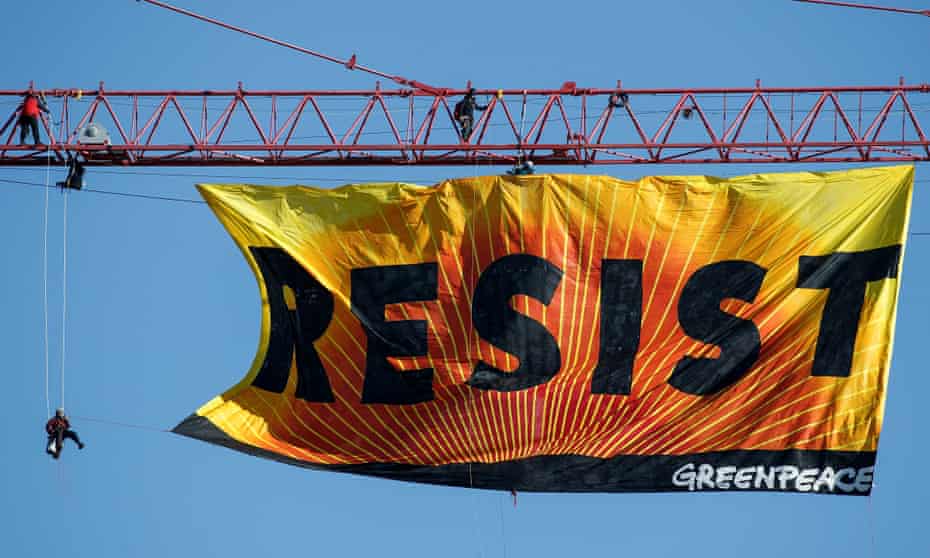 Greenpeace protesters Climb Atop A Crane In Washington, D.C to unfurl a banner that reads Resist