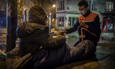 A French Civil Protection volunteer serves a coffee to a homeless man in the streets of Paris, France 10 March 2021. French Civil Protection roamed to meet the homeless to distribute food and basic necessities since the start of the coronavirus pandemic, which has worsened the situation of people living in the streets.