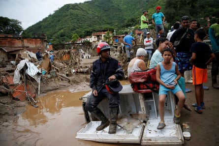 People near the scene of a landslide caused by heavy rains in Las Tejerias, Venezuela, on 9 October