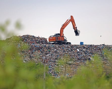 Machinery operates on a large expanse of waste