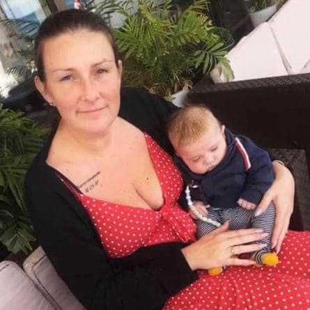 Carla Cardwell with a young baby on her lap smiles for the camera