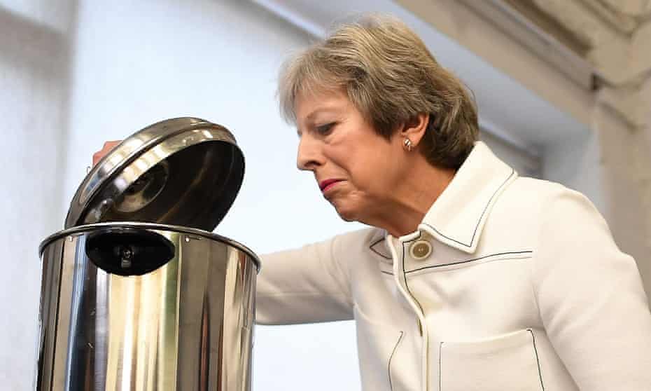 Theresa May peers into a hot water urn on a visit to a social group