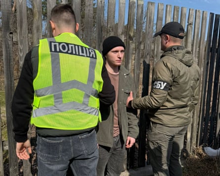 Bohdan Tymchenko flanked by two security officers who are holding his arms