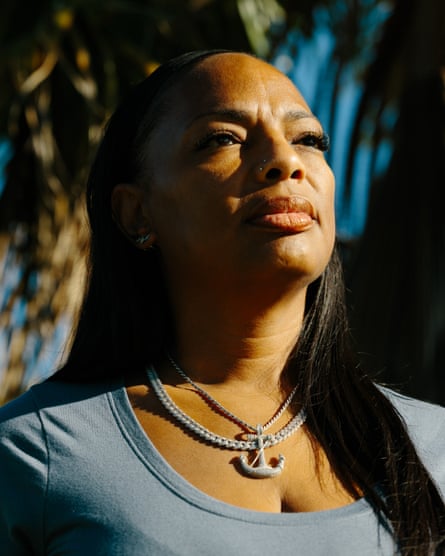 Woman with an anchor necklace stands for a portrait in front of a palm