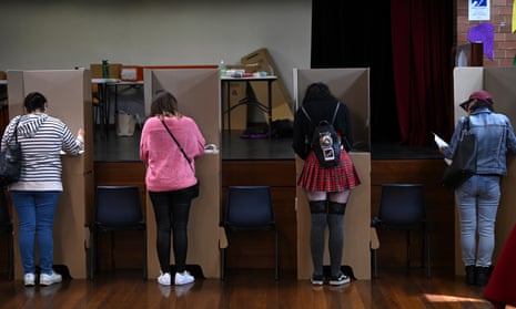 Voters fill in their ballets at a polling booth