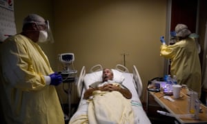 Dr Shane Wilson, left, chats with Covid-19 patient Glen Cowell as the 68-year-old farmer rests inside Scotland County Hospital in Memphis, Missouri.