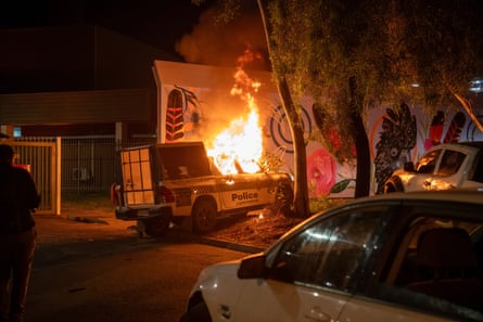 A police vehicle set alight during clashes between outside Alice Springs hospital.