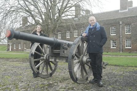 A man and a woman next to a cannon