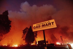 Smoke and flames rise behind a gas station sign in Greenville.