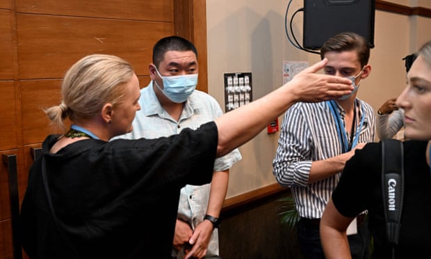 One of the Chinese officials is asked to leave the media area.