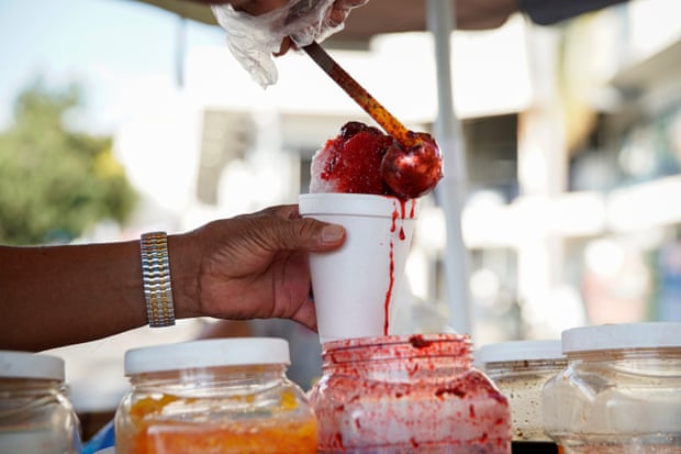 A Los Angeles salesman prepares a frozen ice cream treat during a California heat wave.