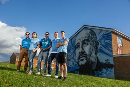 The friends pictured by a mural of Manchester City manager Pep Guardiola opposite the Etihad Stadium