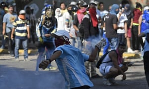 Anti-government protesters returns a tear gas canister during clashes with security forces on Wednesday.