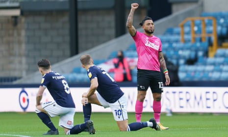 Millwall players take a knee while Derby’s Colin Kazim-Richards stands in protest before the kick-off at the New Den.