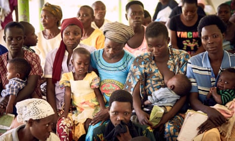Ugandan women, many with babies or young children, at a community event