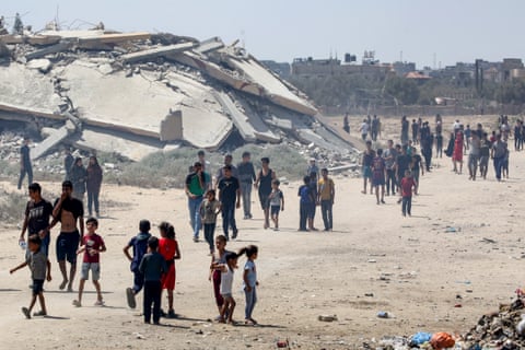 Displaced Palestinians make their way towards the site of a humanitarian aid airdrop at the Bureij camp in Gaza on Sunday. qhiukiqrihuinv