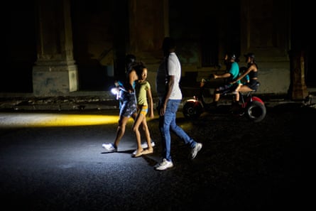 People walk on a dark street during a blackout in Havana