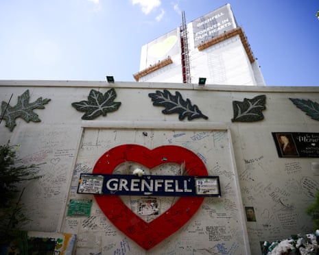 A red heart memorial with a "Grenfell" sign covered in handwritten tribute messages