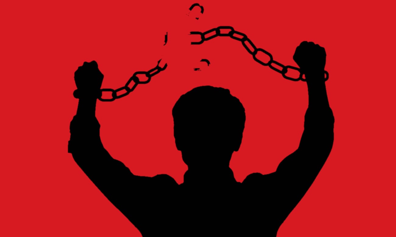 A silhouette of a man breaking the chains on his arms