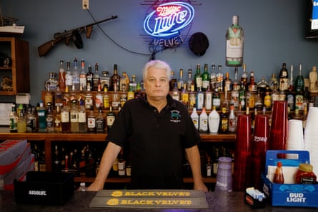 Man in black shirt stands for portrait behind a bar counter