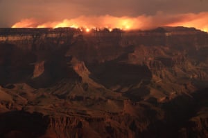 Flames and smoke seen on the other side of a rim of the Grand Canyon