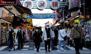 Pedestrians wearing protective masks seen in Tokyo, Japan, as the country approves the Moderna vaccine for booster shots.