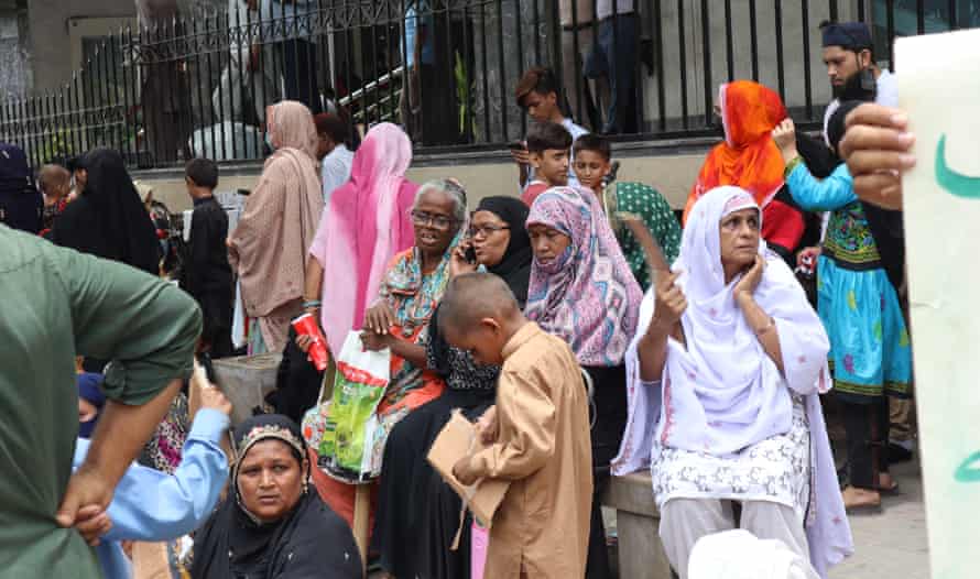 Maqsooda Bibi, on right, attempts to keep cool during a protest in Karachi against the demolitions.