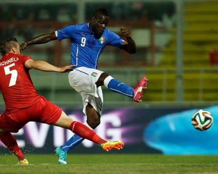Mario Balotelli trying to kick a football during a match.