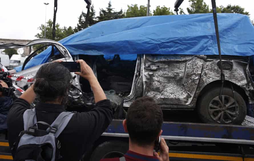 The remains of a car used in the blast is removed from the explosion site.