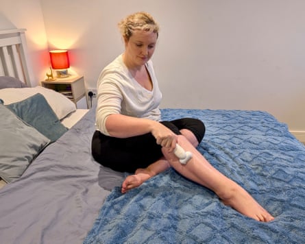 The writer uses an epilator while sitting on a bed.