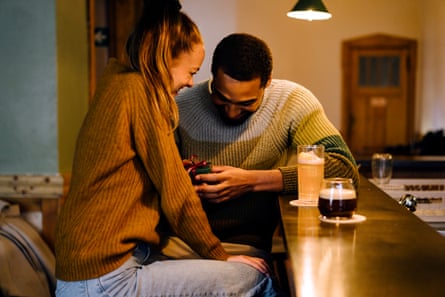 A woman with a man opening a gift.