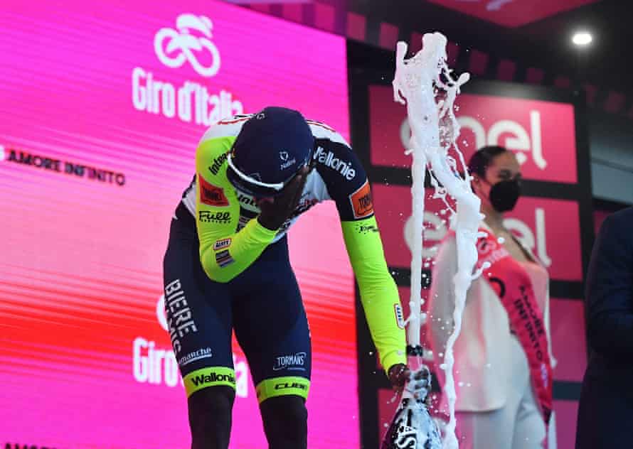 Biniam Girmay takes a cork to the eye on the podium after winning stage 10.