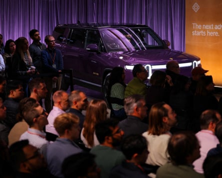 People crowd around a car.