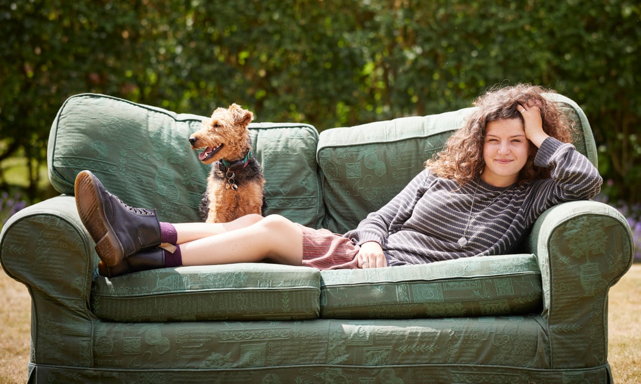 Maeve, a generation Z-er, on a sofa outside with her dog.