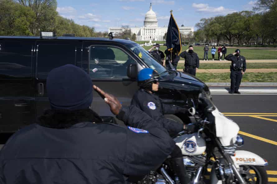 Capitol police officers salute as a procession carries the remains of the officer killed.
