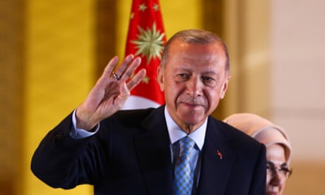 Turkey’s president, Recep Tayyip Erdogan, raises his hand to listeners of his acceptance speech at the presidential palace in Ankara, Turkey.