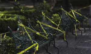 Une bande de mise en garde est enroulée autour des bancs du parc pour décourager les gens de s'asseoir dessus sur la place principale de Coyoacan, à Mexico, samedi 4 avril 2020.