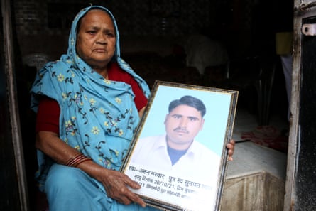 Kamla Devi holds a picture of her son, Arun Valmiki, at her house in Agra, Uttar Pradesh.