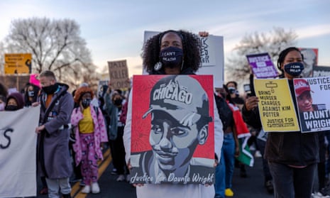 Demonstrators hold posters of Daunte Wright during a protest near the Brooklyn Center police department in Brooklyn Center, Minnesota 16 April 2021.